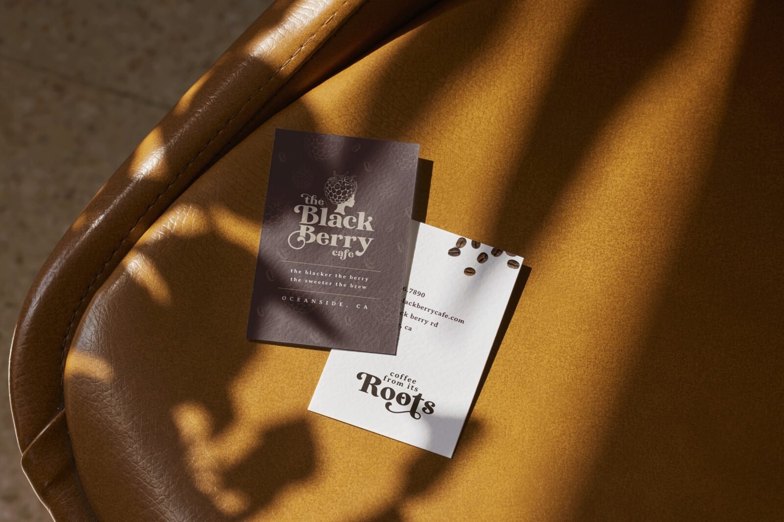 The Black Berry Cafe business cards on gold, with the berry logo and Roots wordmark